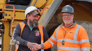 Seb & Rob shake hands in front of a B&A Dozer
