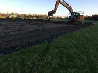digger leveling off topsoil