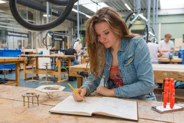 SintLucas student makes a drawing in a notebook to plan her project
