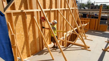 Smartply walls being built by man in hard hat and hi vis jacket