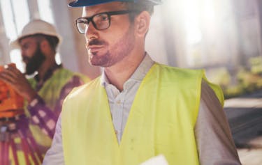 Building contractor wearing high visibility jacket and hat